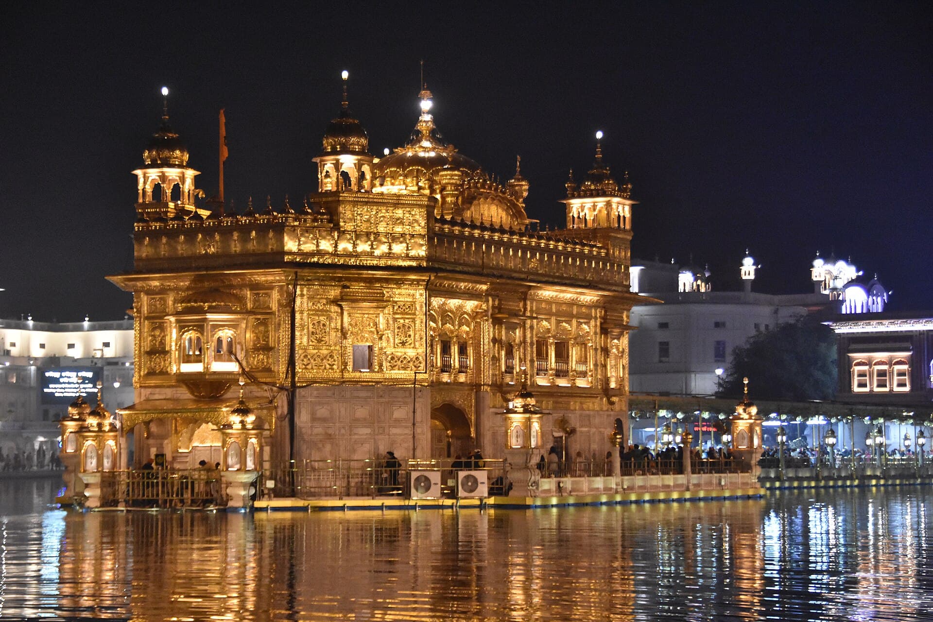 Harmandir Sahib illuminated at night, reflected in the sarovar
